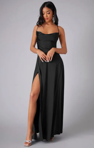 Female in an elegant satin gown with high slit detail against a plain background.