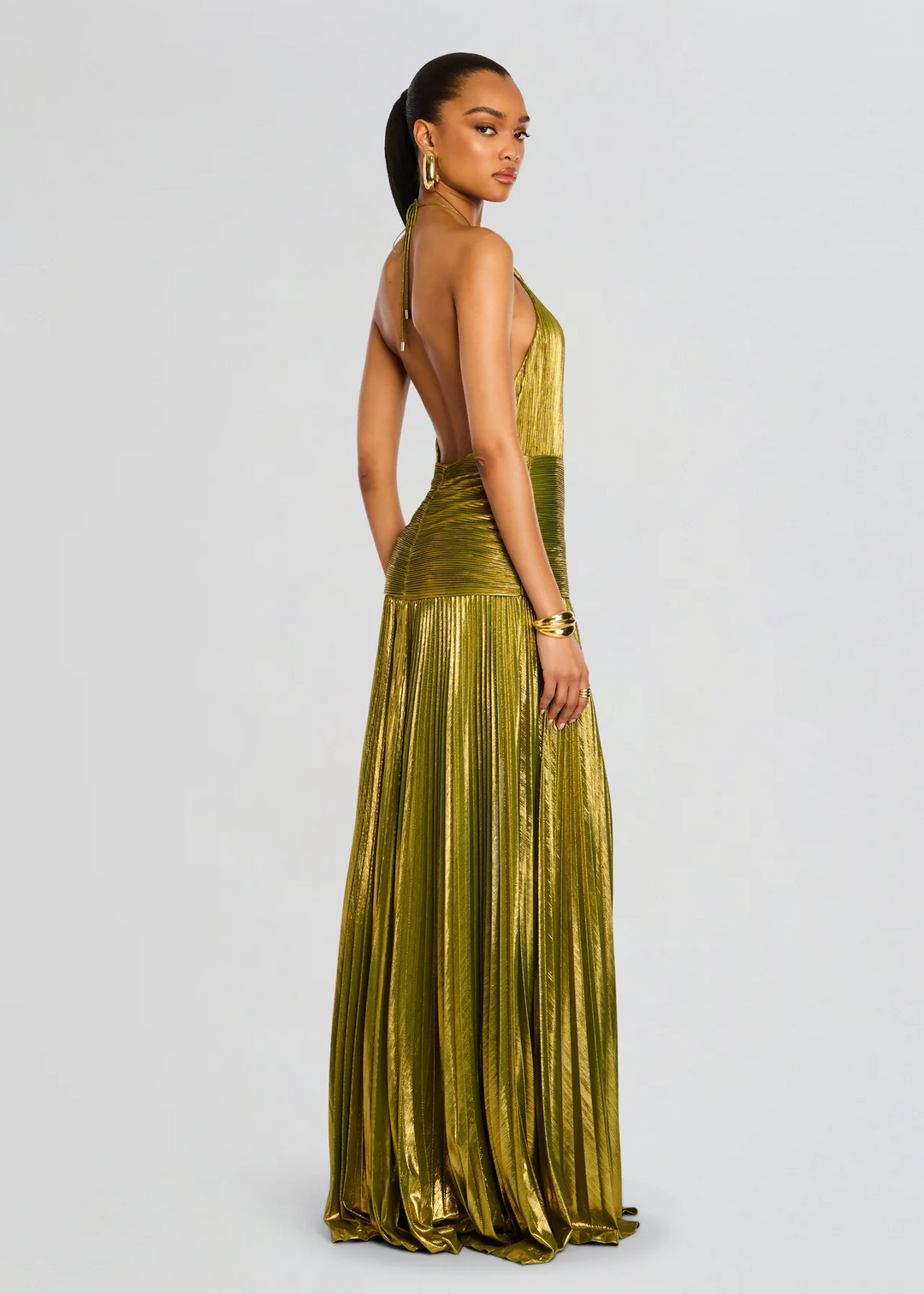 Woman standing in refined evening shoes on a clean plain backdrop.