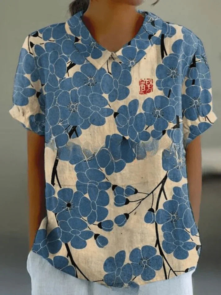 Woman wearing a breathable floral blouse against a plain background.