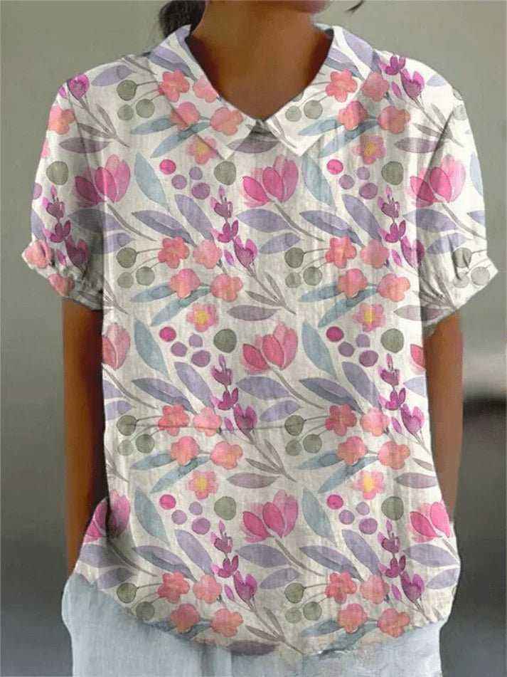Female model showcasing a collared floral blouse on a clean background.