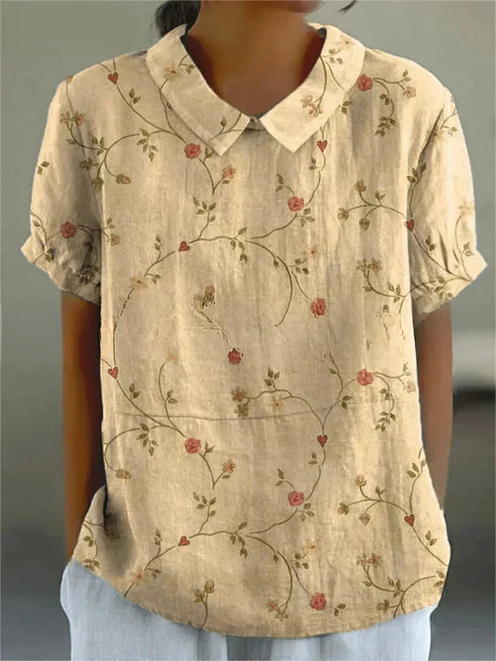 Woman styling a relaxed fit floral blouse on a plain background