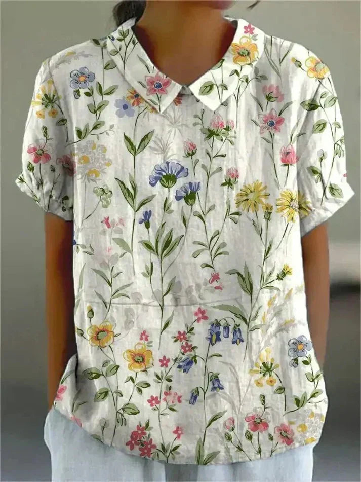 Female model wearing a collared floral shirt with a clean background.