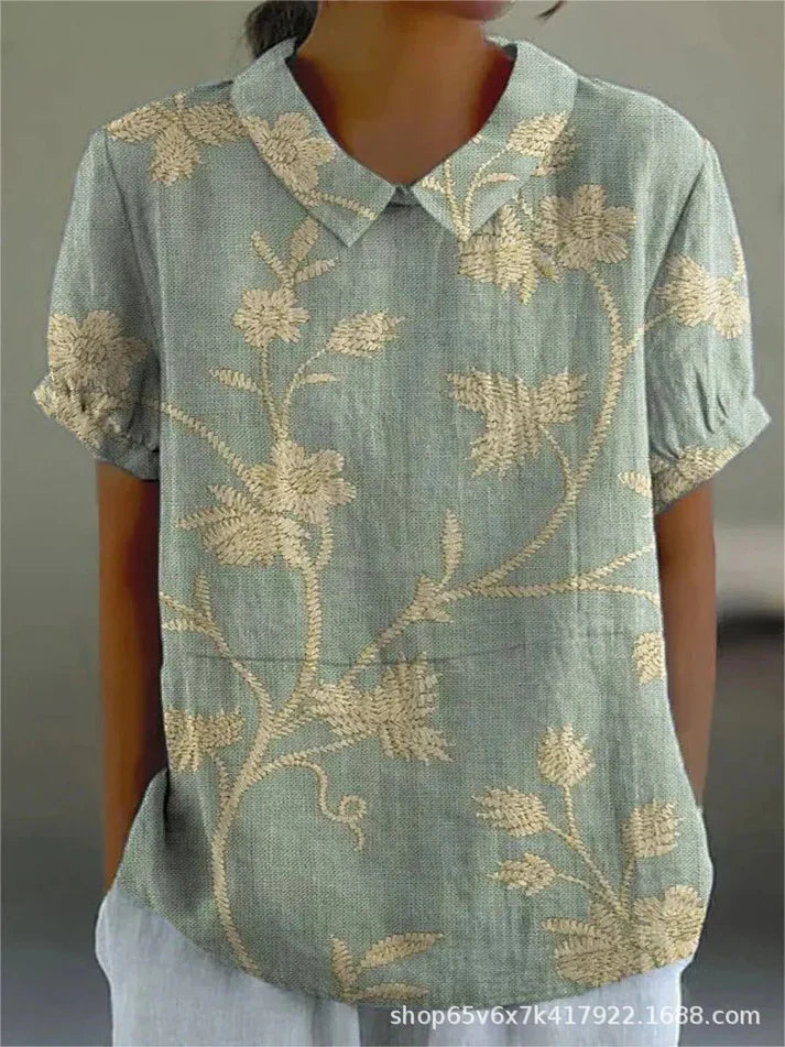 Woman in a casual floral blouse against a plain background.
