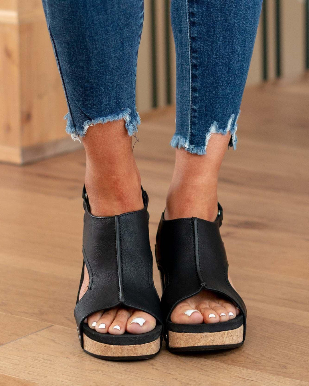 Front angle foot model showcasing adjustable sandals on brown floor