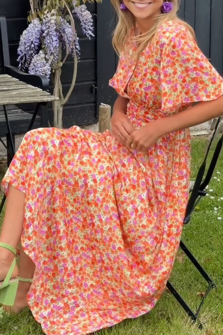 Mode seating wearing flowy dress photographed in outdoor setting