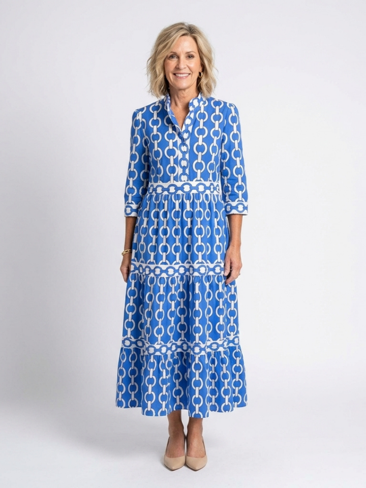 Woman wearing a chain print midi dress with 3/4 sleeves against a plain background.