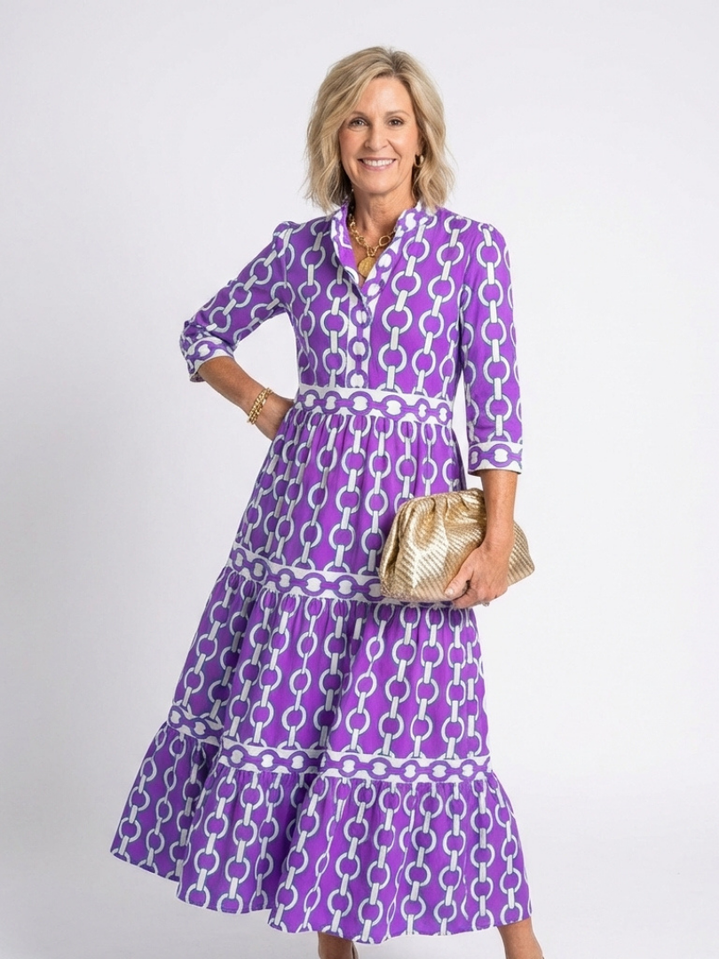 Model standing in a v-neck chain print midi dress with relaxed silhouette.