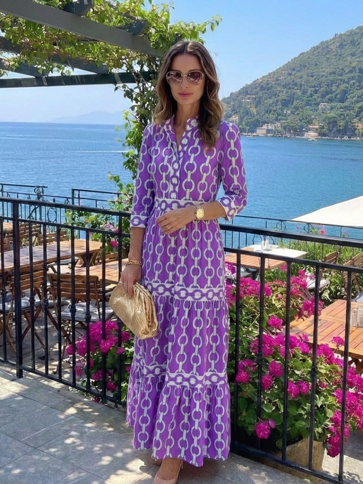 Woman in a contemporary chain print dress with tiered design and nature backdrop.