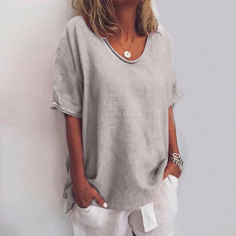 Woman wearing loose short sleeve blouse on plain background front view.