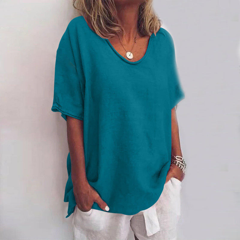 Female model wearing elegant loose blouse on plain background close-up.