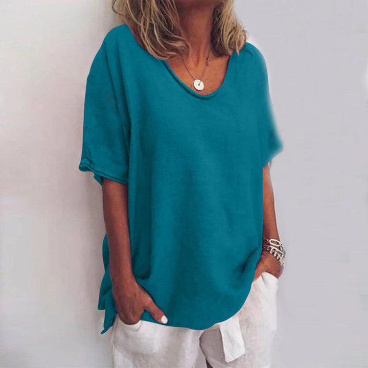 Female model wearing elegant loose blouse on plain background close-up.