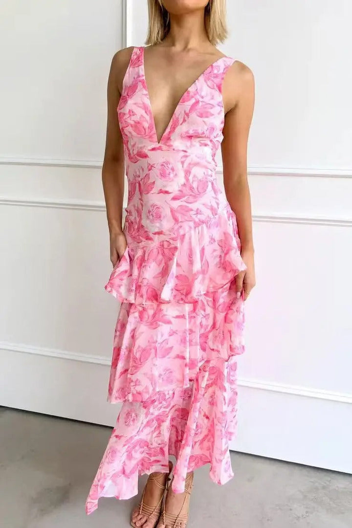Model relaxed pose in long floral dress plain background