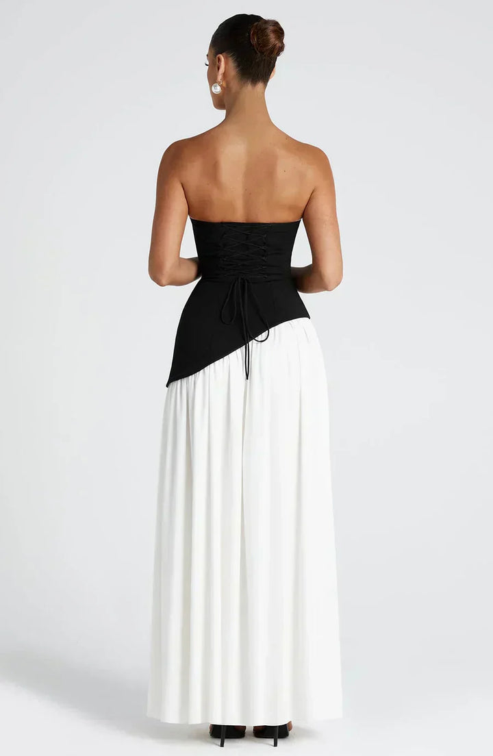 Model posing in polished maxi dress against plain background, back view