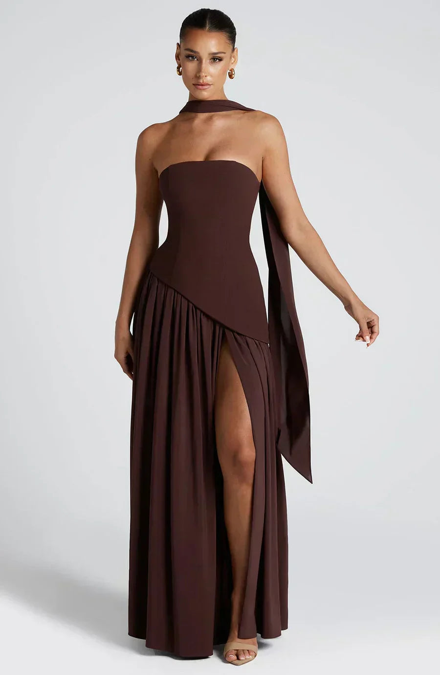 Woman wearing a full-length asymmetric dress styled for special occasions.
