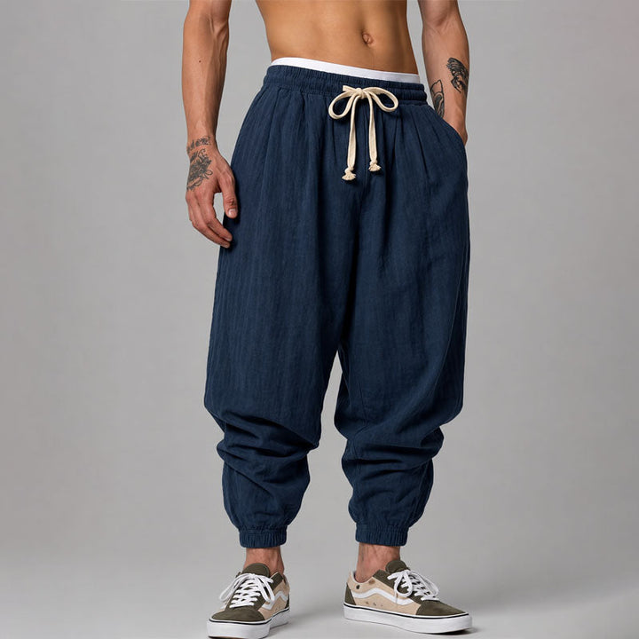  Model showing casual tapered pants with side pockets against a plain background.