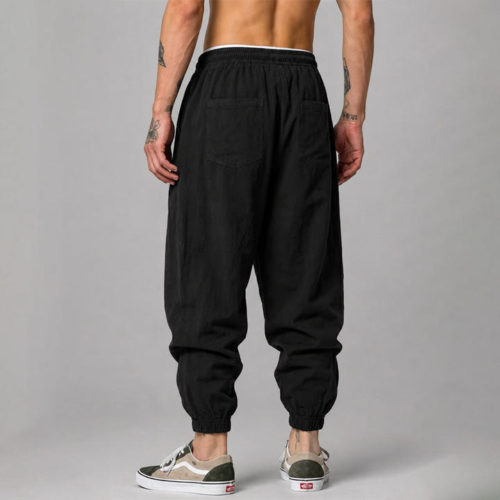  Female model wearing drawstring jogger pants with side pocket detail against a plain background.