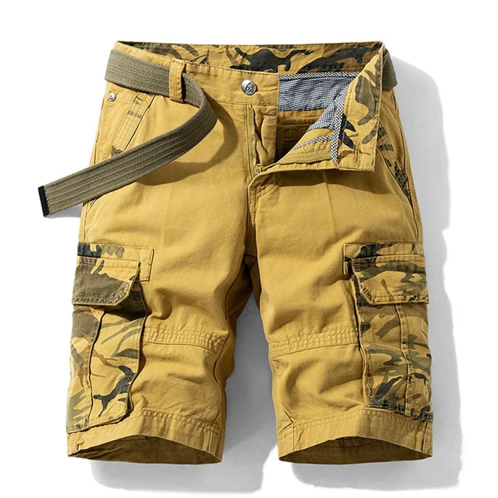 Male model wearing cotton cargo shorts with multiple pockets against a plain background.