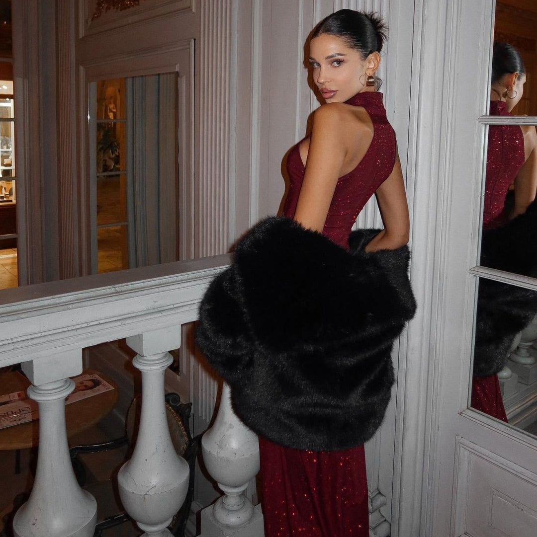  Female model in an eye-catching evening gown against a plain background.