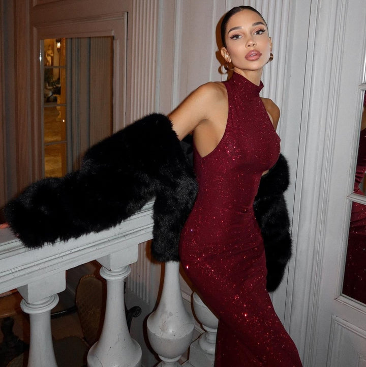  Woman in a radiant evening outfit featuring all-over sparkle on a plain background.