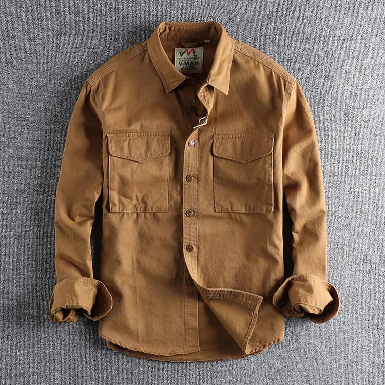 A classic long sleeve work shirt with front pockets against a plain background.