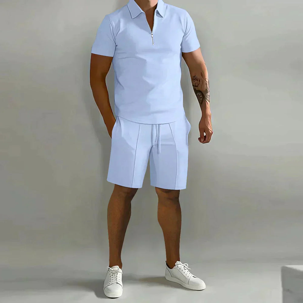  Male model showcasing a coordinated polo shirt and shorts outfit on a plain background.