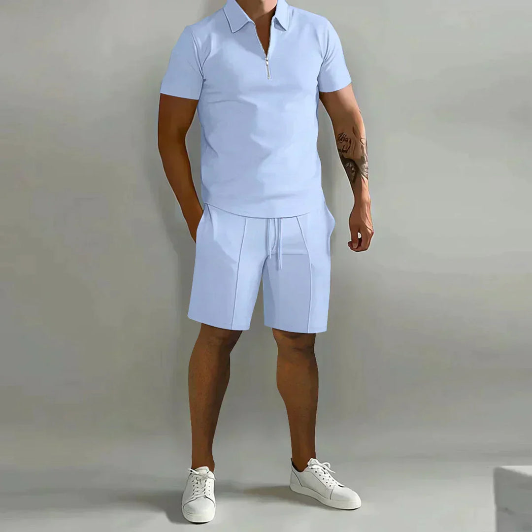  Male model showcasing a coordinated polo shirt and shorts outfit on a plain background.