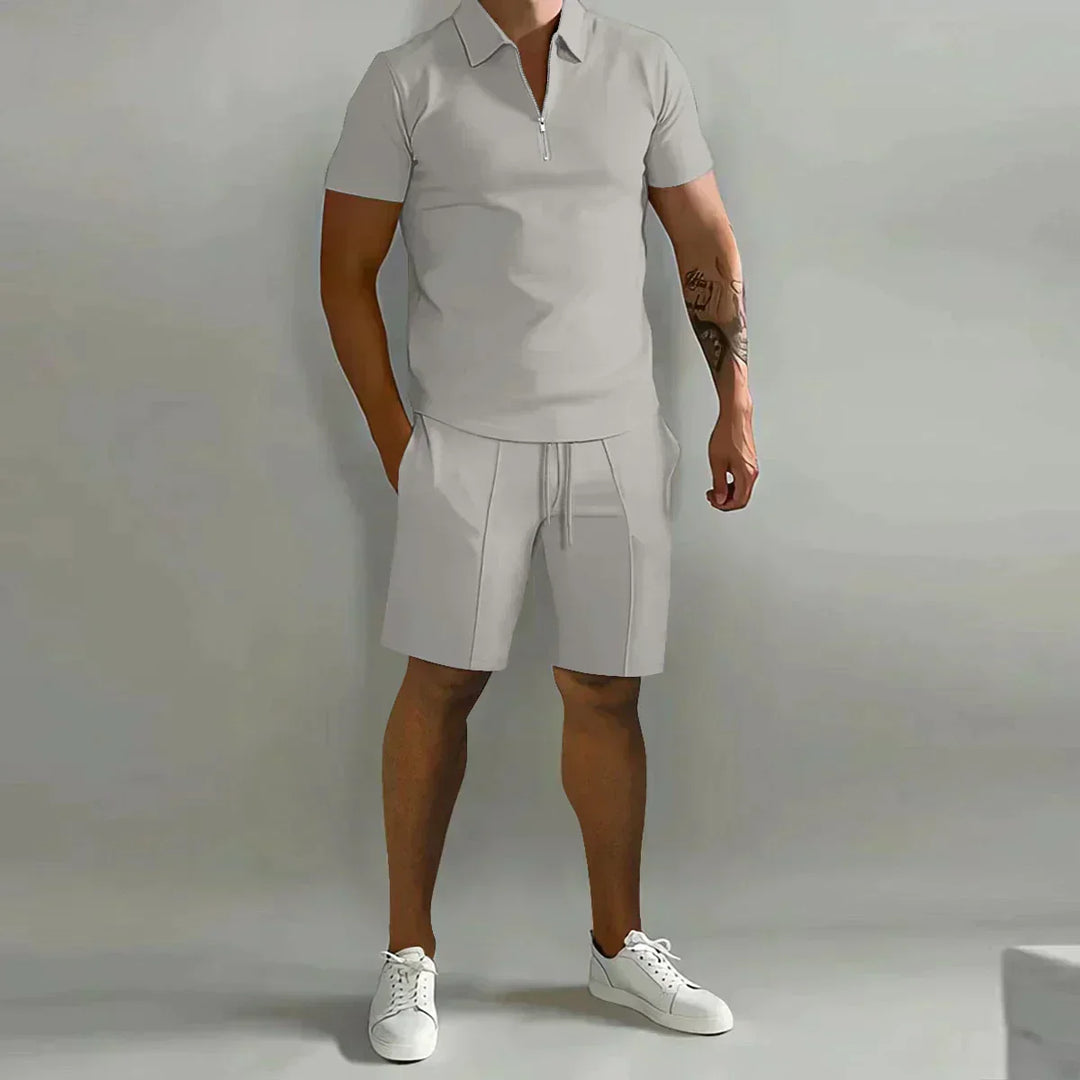  Male model wearing a half-zip collar shirt with coordinating shorts on a plain background.