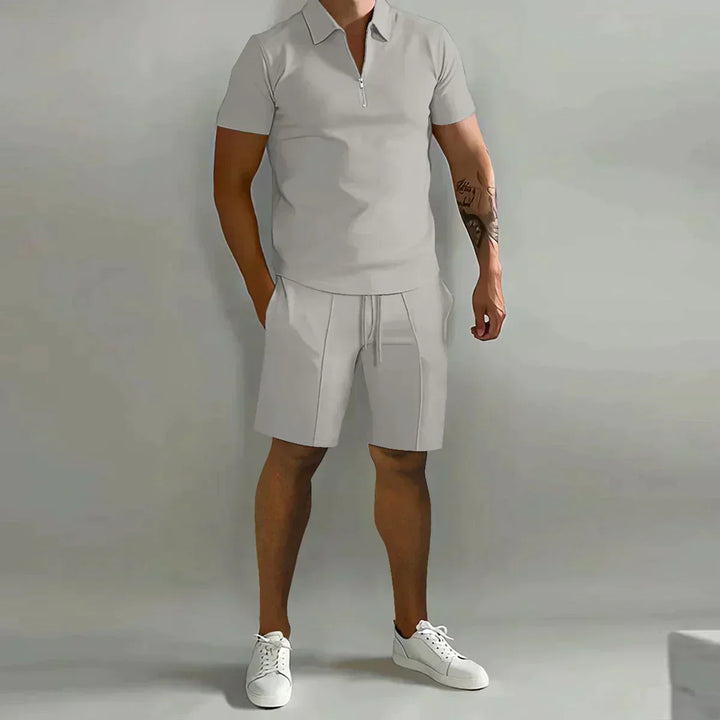  Male model wearing a half-zip collar shirt with coordinating shorts on a plain background.
