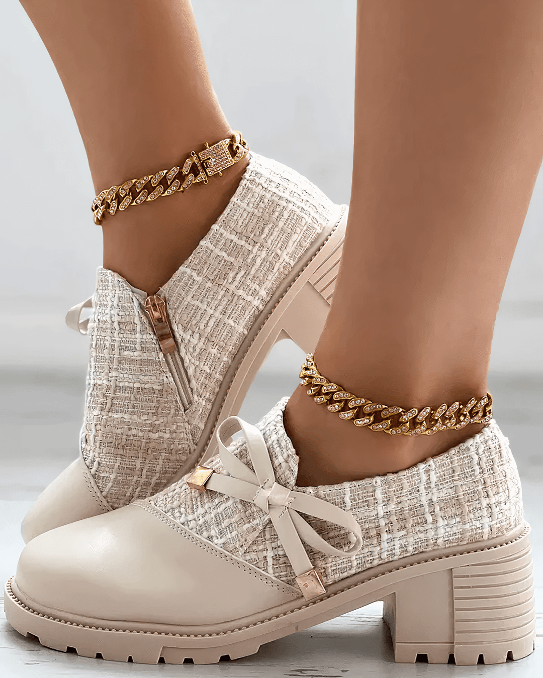 Side view foot model wearing block heel loafers plain background