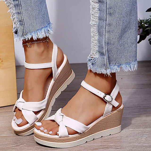Side view of wedge sandals on foot model plain background