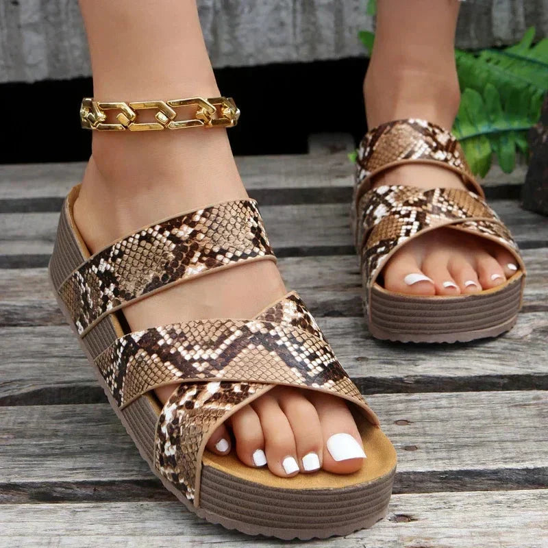  Female displaying platform sandals with woven-style strap detail on a plain background.