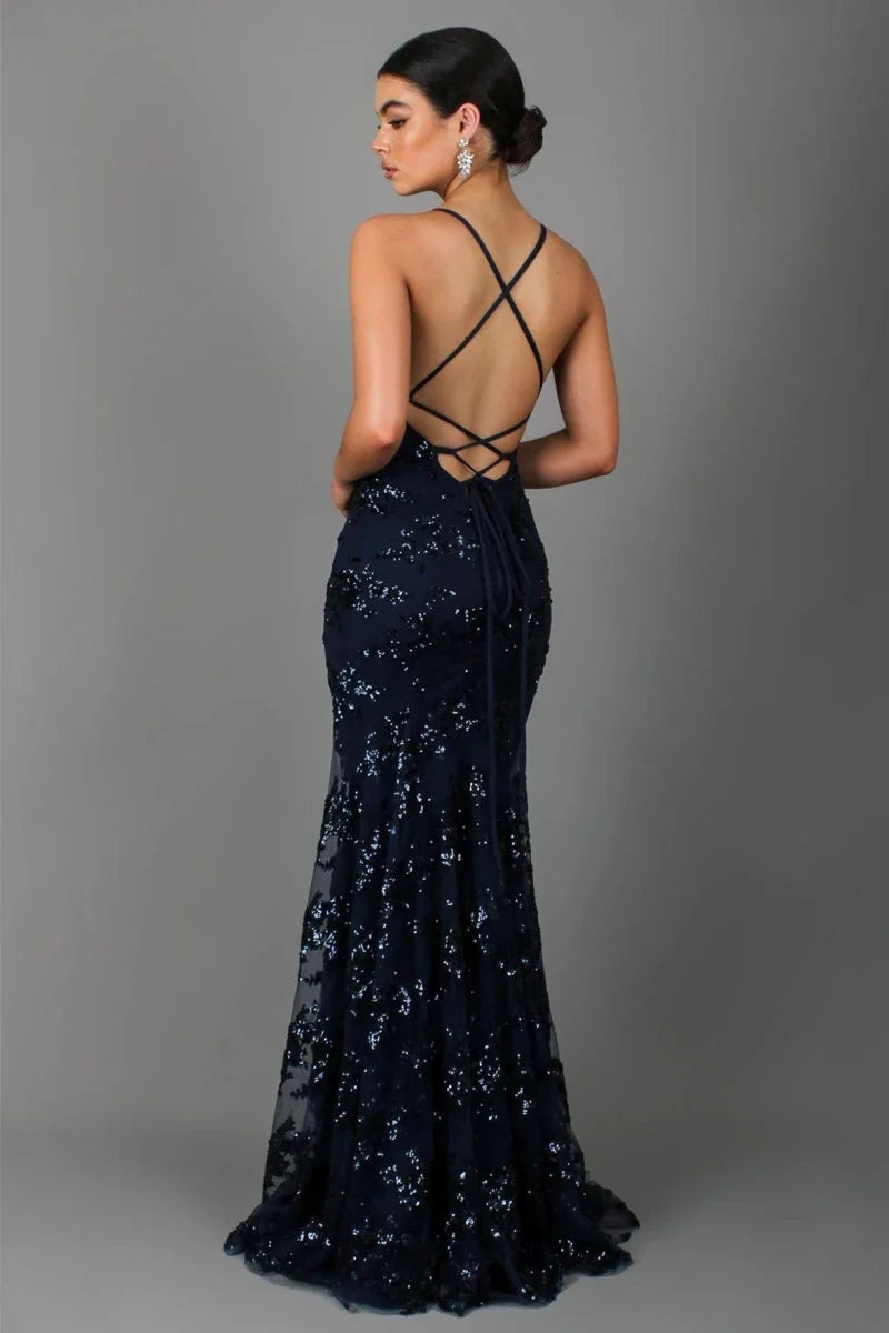  Woman in a sequin evening gown with open back detail on a plain background.