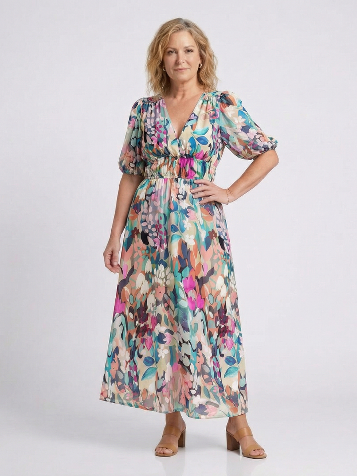 Female model showcasing a floral V-neck dress in a studio setting.