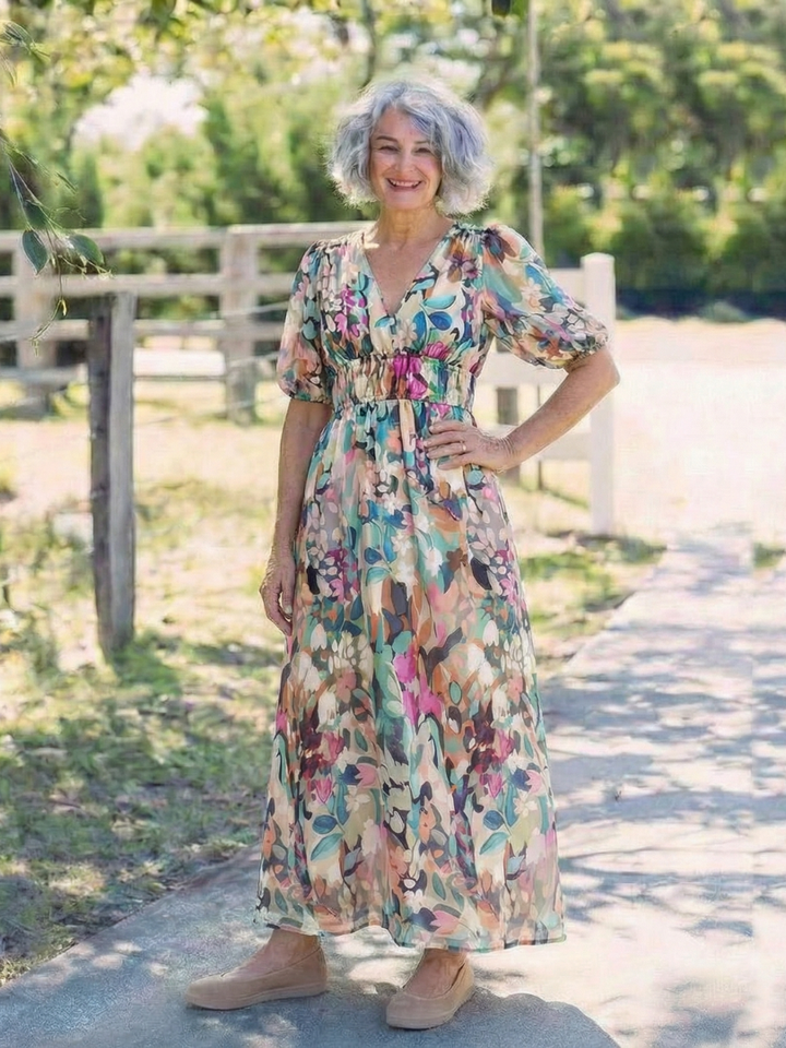 Woman wearing a relaxed-fit floral midi dress with short sleeves.