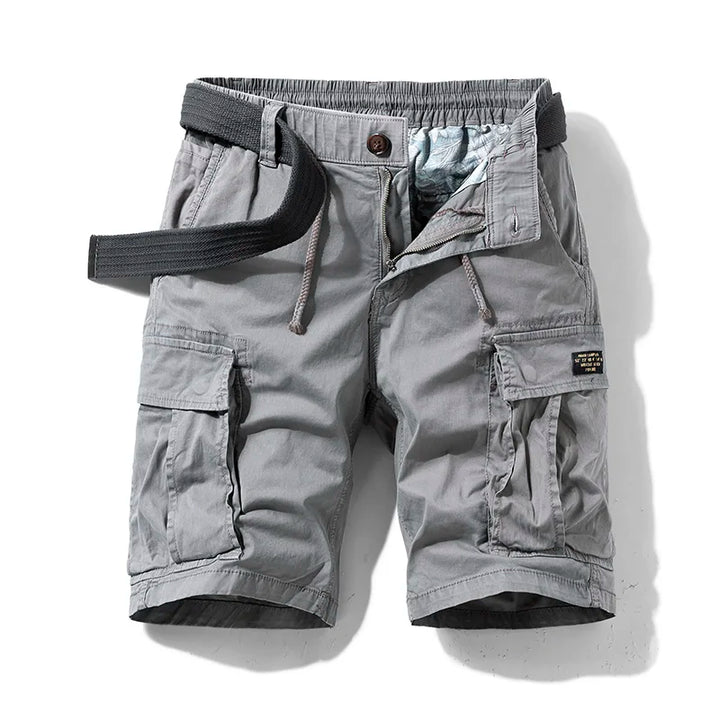 Male model wearing cotton cargo shorts against a plain background.