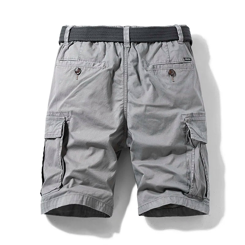  Model standing in casual cotton cargo shorts with pocket detail on a plain background.
