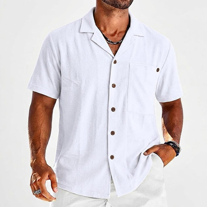  Male model wearing a casual open collar shirt with chest pocket detail.