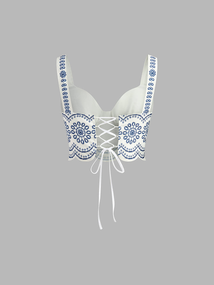 A cropped strap top on a plain background.