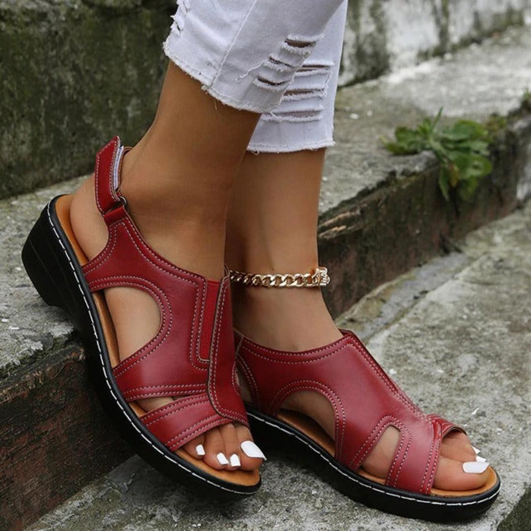 Close up toes wearing sandals on plain cement background scene