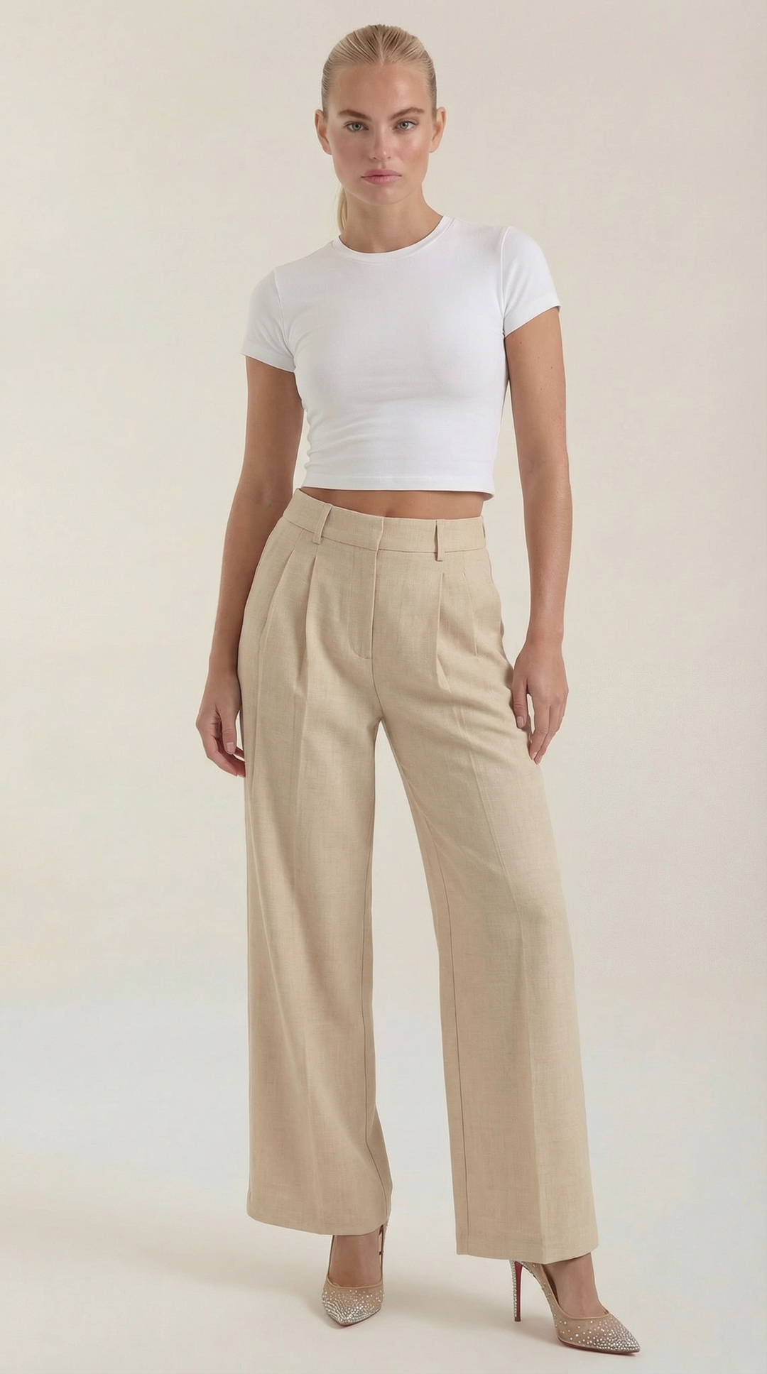 Woman wearing pleated wide-leg pants front view on plain background.