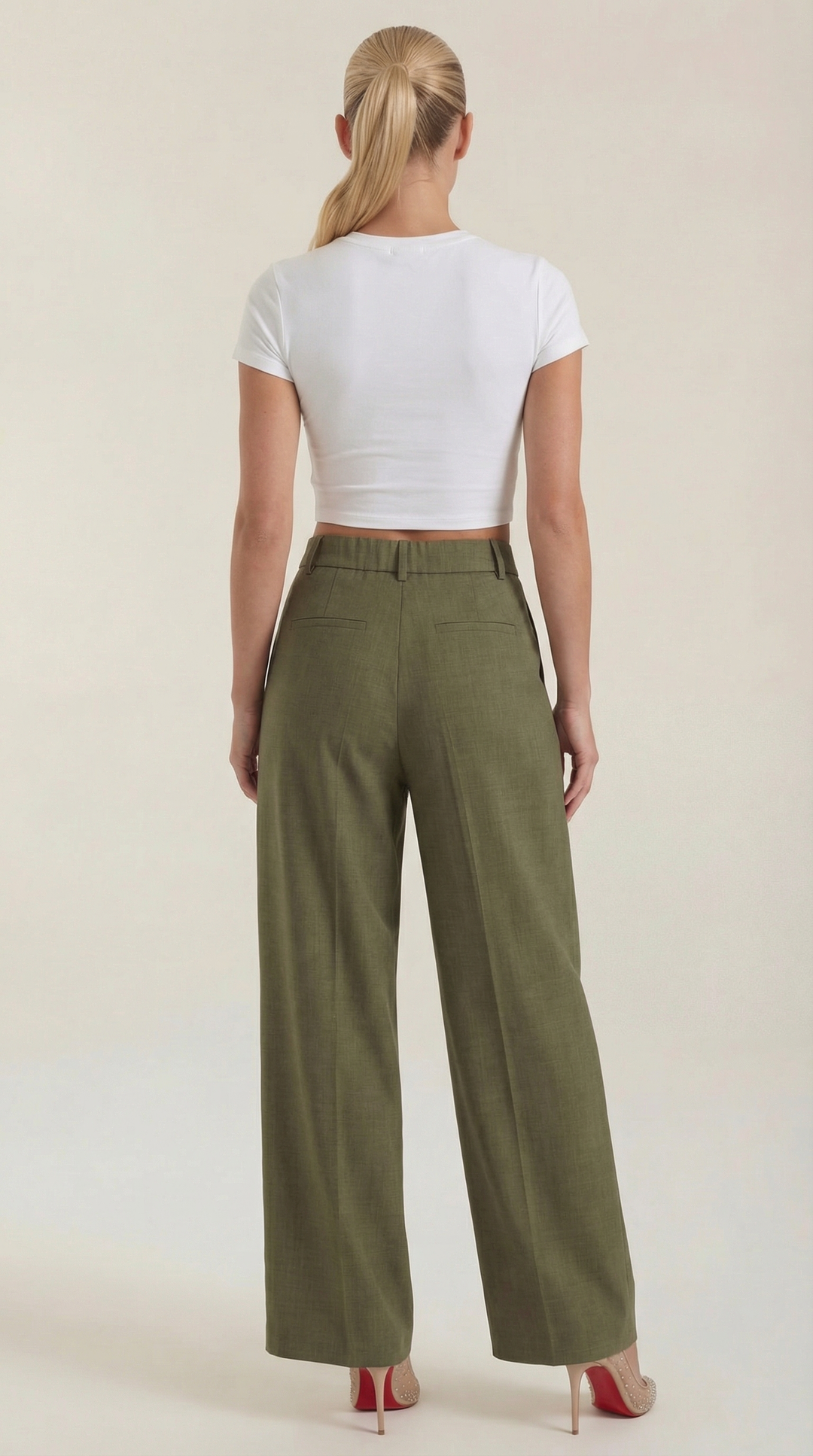 Woman showing smooth fit of trousers side plain background, back view