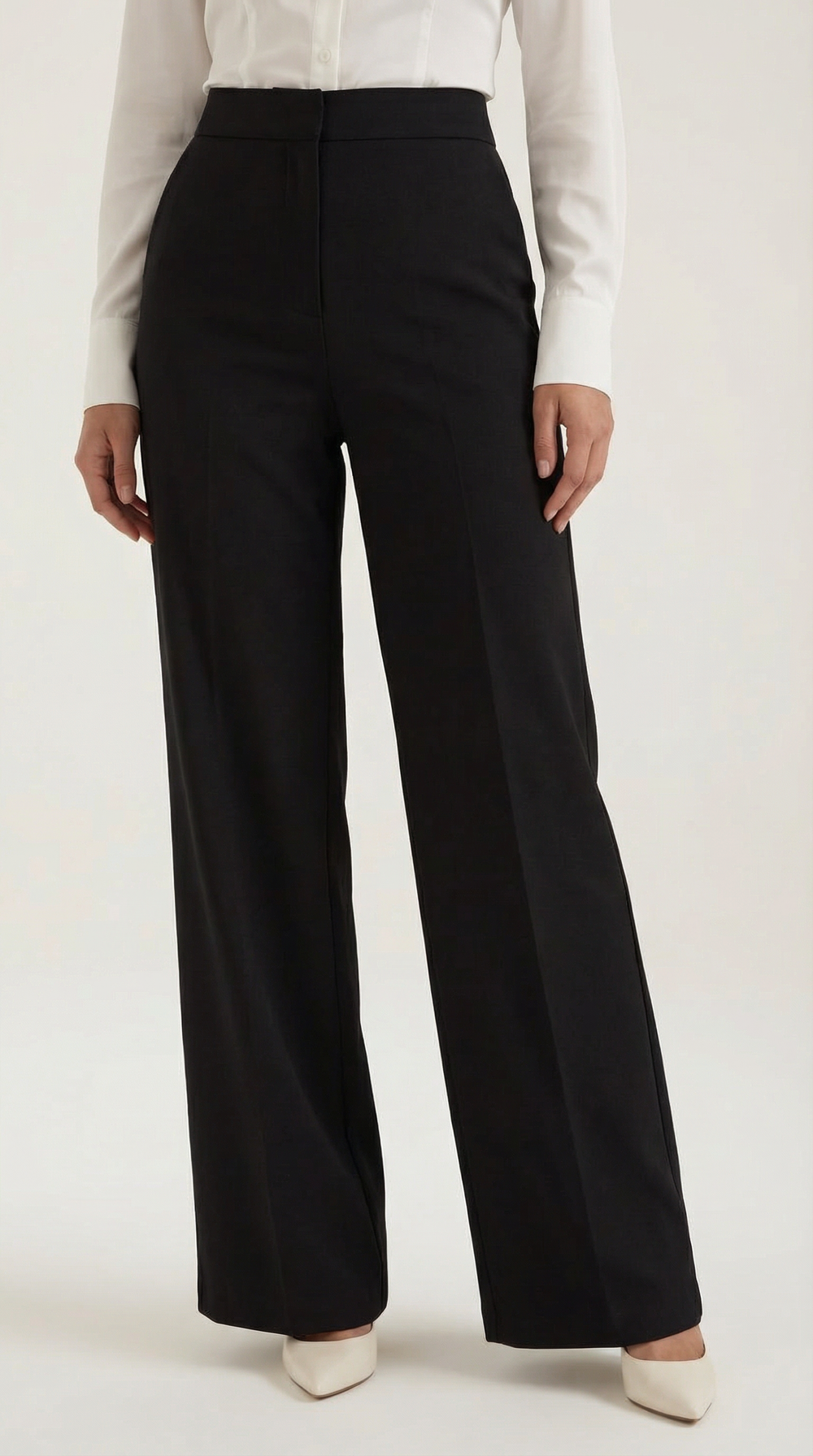 Female model side angle tailored trousers minimalist plain background lighting