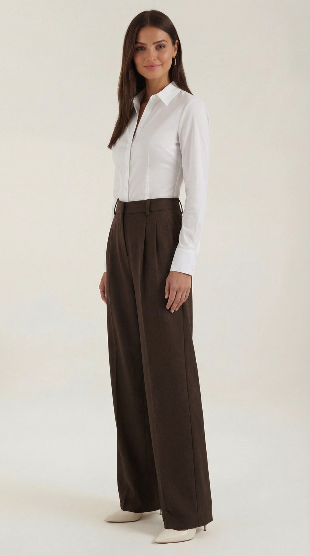 Woman seated wearing high-waist trousers plain background clean aesthetic