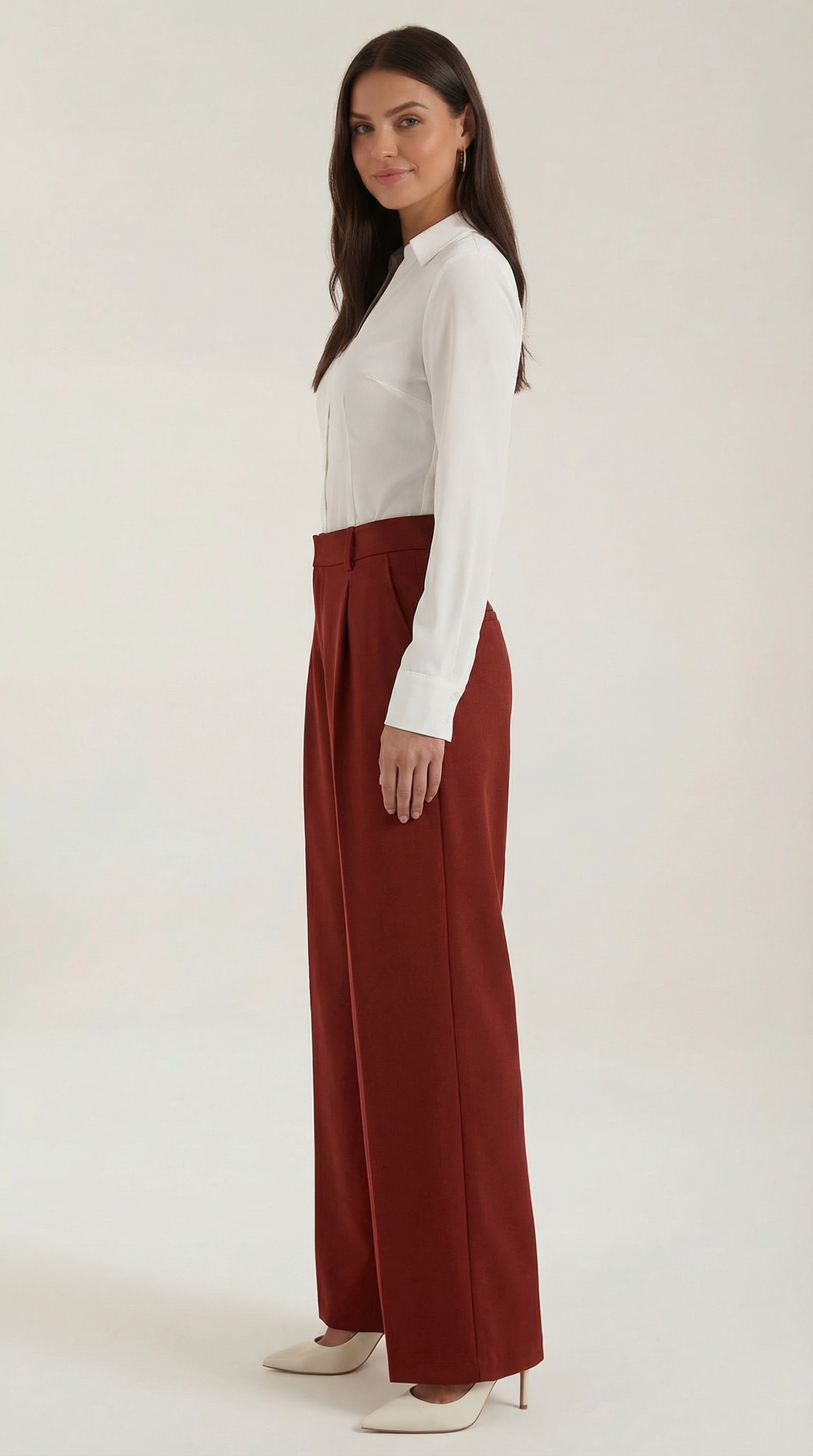 Side pose woman wearing structured trousers plain background modern look