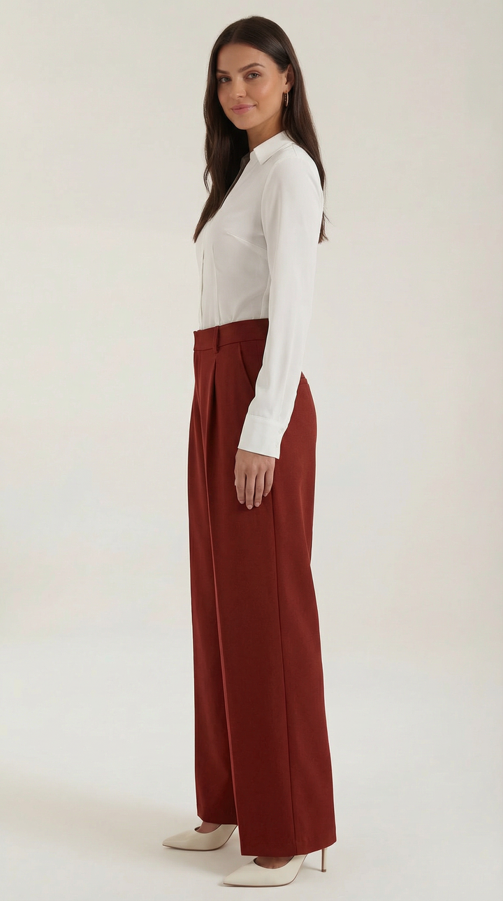 Side pose woman wearing structured trousers plain background modern look