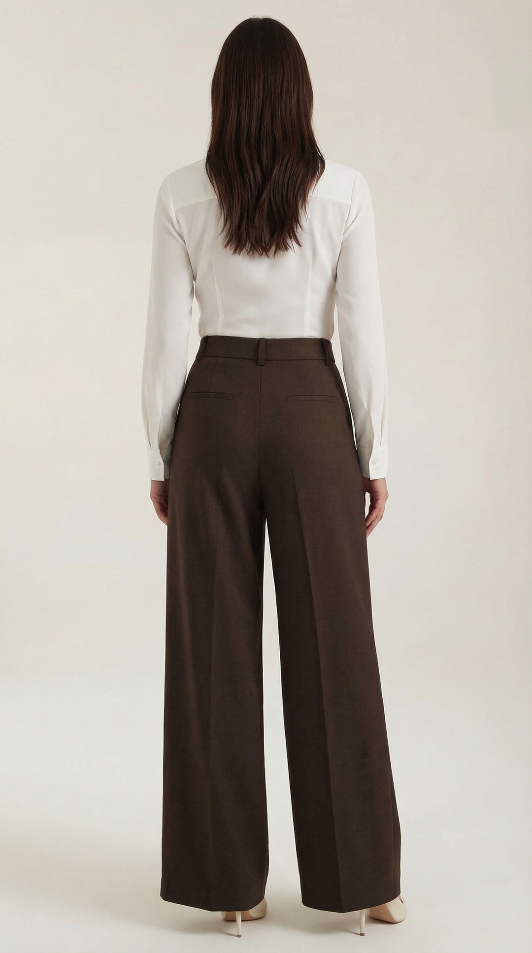 Female model posing back wide-leg trousers plain background minimal