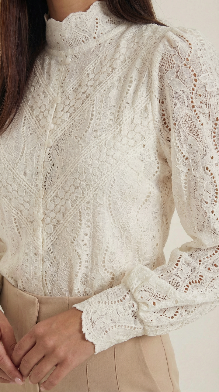 Female model close-up relaxed wearing mock neck blouse plain background
