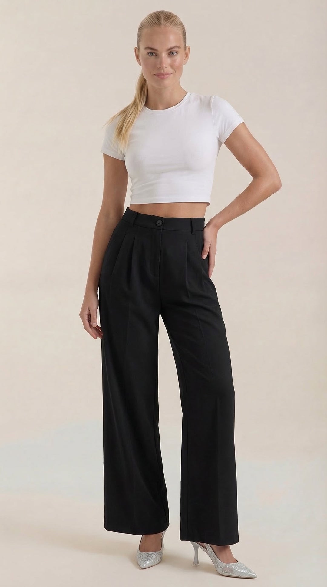 Woman wearing wide-leg trousers standing with plain background