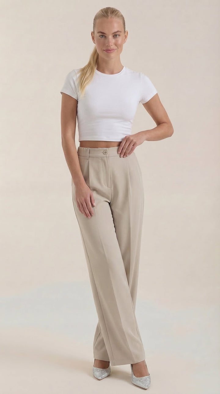 Woman in elegant wide-leg trousers, side view, plain background.
