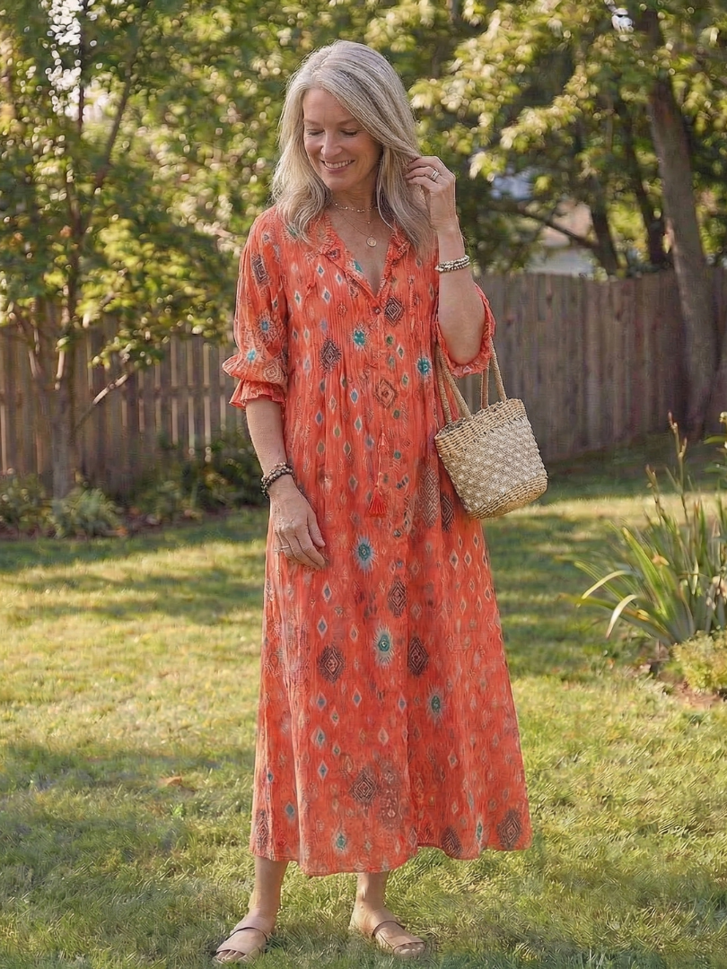 Long floral maxi dress with 3/4 sleeves displayed on a female model against a nature backdrop.